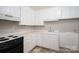 Compact kitchen with white cabinets and countertops, and black appliances at 1501 Fern Forest Dr, Gastonia, NC 28054