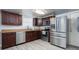 This kitchen features stainless steel appliances, wood look flooring, and dark wood cabinets at 1501 Fern Forest Dr, Gastonia, NC 28054