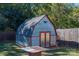 Metal storage shed with red door, roof, and siding details located in a grassy backyard with a wooden fence at 1501 Fern Forest Dr, Gastonia, NC 28054