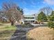 Charming two-story home featuring a green metal roof, covered porch, and a winding driveway at 1612 Forum Ln, Iron Station, NC 28080