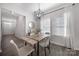Dining room with modern light fixture, wood-look flooring and lots of natural light from the large windows at 212 Briana Marie Way, Indian Trail, NC 28079