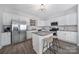 Modern kitchen with white cabinets, stainless steel appliances, and a stylish island at 212 Briana Marie Way, Indian Trail, NC 28079