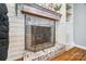 Living room fireplace with whitewashed brick, wooden mantle, and adjacent built-in shelving at 228 Lakeview Dr, Belmont, NC 28012