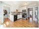 Well-lit kitchen with stainless steel appliances, white cabinets and a view to laundry room at 285 Fryling Sw Ave, Concord, NC 28025