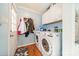 Bright laundry room with modern washer, dryer, storage cabinets, and hardwood floors at 285 Fryling Sw Ave, Concord, NC 28025