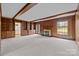 Cozy living room featuring wood paneling, built-in bookshelves, and a fireplace with decorative tile surround at 3107 Cloverfield Rd, Charlotte, NC 28211