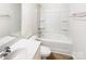 Bathroom with shower and tub combination with white tile surround, sink, and towel bar at 3113 Ellingford Rd, Charlotte, NC 28214