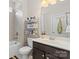 Well-lit bathroom with a shower-tub combination, floating shelves, and a modern dark vanity at 3114 Woodlands Creek Dr, Monroe, NC 28110