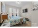 A well-lit bedroom features carpet, a queen bed with light blue covers and a television mounted on the wall at 3114 Woodlands Creek Dr, Monroe, NC 28110