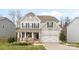 Charming two-story home features a covered front porch and a two-car garage at 3114 Woodlands Creek Dr, Monroe, NC 28110