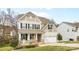 Charming two-story home features a covered front porch and a two-car garage at 3114 Woodlands Creek Dr, Monroe, NC 28110