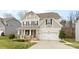 Charming two-story home features a covered front porch and a two-car garage at 3114 Woodlands Creek Dr, Monroe, NC 28110