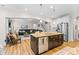Open-concept kitchen flows into the living room; features island with sink at 3114 Woodlands Creek Dr, Monroe, NC 28110