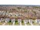 An aerial view displays a charming neighborhood surrounded by woods on a sunny day at 3114 Woodlands Creek Dr, Monroe, NC 28110