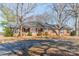 Brick ranch-style home with mature trees and a wide driveway at 4210 Wrangler Sw Dr, Concord, NC 28027