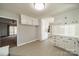 Clean, white kitchen offers cabinet space, and a breakfast bar, and flows into the dining area at 4210 Wrangler Sw Dr, Concord, NC 28027