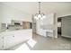 Bright kitchen featuring white cabinets, countertop seating and modern light fixture at 4210 Wrangler Sw Dr, Concord, NC 28027