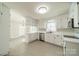 Bright kitchen with white cabinets, stainless steel appliances, and laminate wood floors at 4210 Wrangler Sw Dr, Concord, NC 28027