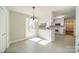 Bright kitchen featuring white cabinets, countertop seating and modern light fixture at 4210 Wrangler Sw Dr, Concord, NC 28027