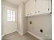 Functional mud room with white cabinets, door to the outside, and durable flooring at 4210 Wrangler Sw Dr, Concord, NC 28027