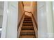 Carpeted stairway with white walls and wooden handrail leading to the second story at 4210 Wrangler Sw Dr, Concord, NC 28027