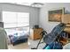 A bright bedroom with a painting, window with blinds, dresser, and inversion table at 4716 Meadowfield Rd, Charlotte, NC 28215