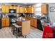 Cozy kitchen featuring wooden cabinets, granite countertops, tile backsplash, and an island with seating at 4716 Meadowfield Rd, Charlotte, NC 28215