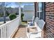 Inviting front porch featuring white wicker chairs and brick accents, perfect for relaxing and enjoying the neighborhood at 4716 Meadowfield Rd, Charlotte, NC 28215