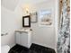 Well-lit bathroom with a white vanity, black tile floor and framed mirror at 590 Main Sw St, Concord, NC 28027