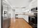 Spacious kitchen with stainless steel refrigerator, white cabinetry and hardwood flooring at 590 Main Sw St, Concord, NC 28027