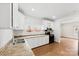 Well-lit kitchen with white cabinets, black appliances, and hardwood flooring at 590 Main Sw St, Concord, NC 28027