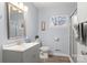 Bright bathroom with a sink, mirror, toilet, and glass-enclosed shower at 7047 Cheyenne Dr, Charlotte, NC 28262