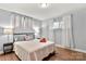 Well-lit bedroom with hardwood floors, large windows, and lamps at 7047 Cheyenne Dr, Charlotte, NC 28262
