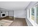 Inviting living room featuring hardwood floors, a fireplace, and large bright window at 7047 Cheyenne Dr, Charlotte, NC 28262