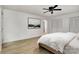 Spacious bedroom with a ceiling fan, light wood flooring, neutral decor, and a large artwork on the wall at 7407 Forney Hill Rd, Denver, NC 28037