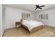 Serene bedroom featuring neutral decor, wood-look flooring, and natural light from shuttered windows at 7407 Forney Hill Rd, Denver, NC 28037
