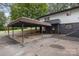 View of the carport and side entrance to the home with brick and vinyl siding and dark trim at 7407 Forney Hill Rd, Denver, NC 28037