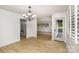 Bright dining room with light wood floors, modern lighting, and a view into the kitchen with stainless appliances at 7407 Forney Hill Rd, Denver, NC 28037