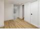 Bright hallway with light wood floors and white walls with doors leading to other rooms at 7407 Forney Hill Rd, Denver, NC 28037