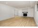 The room is light and open, featuring wood-look floors, a brick fireplace, and recessed lighting at 7407 Forney Hill Rd, Denver, NC 28037