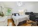 Bedroom with hardwood floors, natural light, white walls and a bed with a plush white comforter and decorative pillows at 7613 Whistlestop Rd, Charlotte, NC 28210