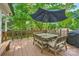 Inviting wooden deck with an umbrella-covered dining set, ideal for outdoor entertaining at 7613 Whistlestop Rd, Charlotte, NC 28210