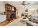 Charming living room with a large brick fireplace, hardwood floors, and comfortable seating with an open view to the dining room at 7613 Whistlestop Rd, Charlotte, NC 28210