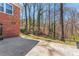 A serene backyard with a concrete patio, mature trees, and natural landscaping at 8101 Kerrybrook Cir, Charlotte, NC 28214