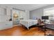 Bright bedroom with hardwood floors, built-in shelving, and two large windows at 8101 Kerrybrook Cir, Charlotte, NC 28214