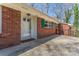 Charming front exterior with brick facade, white trim, a covered porch, and hints of the surrounding trees at 8101 Kerrybrook Cir, Charlotte, NC 28214