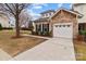 Charming home exterior with a stone accent wall, two-car garage, and landscaping at 8412 Brookings Dr, Charlotte, NC 28269