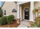 Inviting front door with sidelight, stone accents, and manicured landscaping at 8412 Brookings Dr, Charlotte, NC 28269