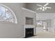 Bright living room featuring a fireplace, a large arched window, and an open layout leading to the kitchen and dining area at 8412 Brookings Dr, Charlotte, NC 28269