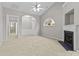 Spacious living room featuring a fireplace, an arched window, and an open layout leading to the foyer and hallway at 8412 Brookings Dr, Charlotte, NC 28269